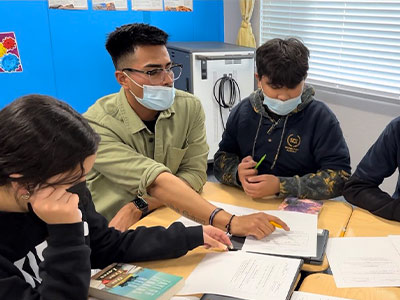 Christian Vasquez MA ’21 helping his students with classwork