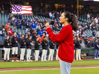 USF alumna singing the national anthem