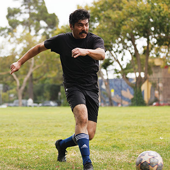 Soccer player kicking ball.