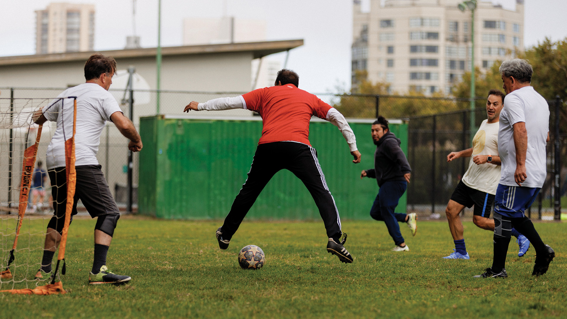 Many soccer players playing on field.