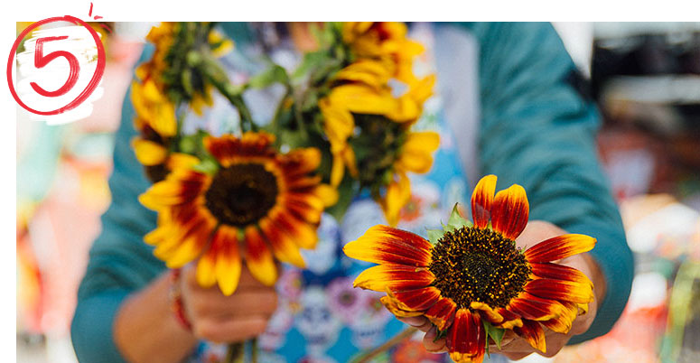 Person holding a bunch of sunflowers 