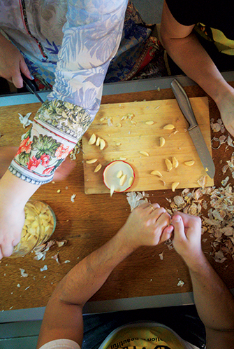 Multiple people chopping garlic