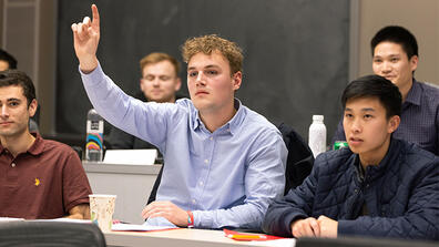 Student raising their hand in class