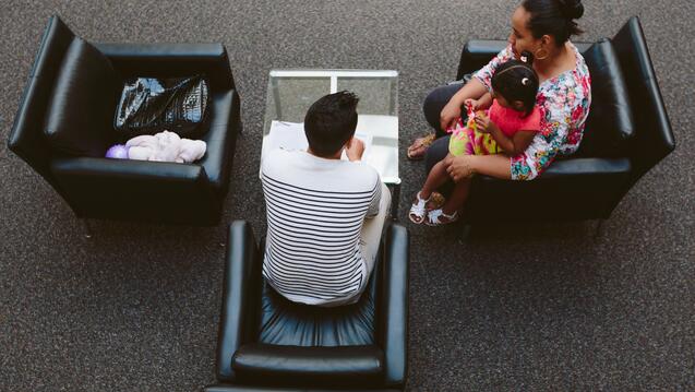 Top view of two people sitting, one holding a chile