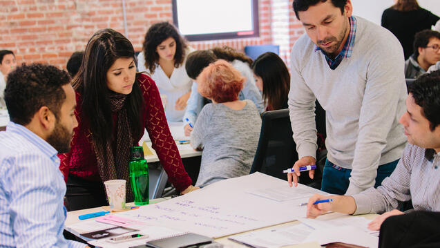 students working with teacher in class