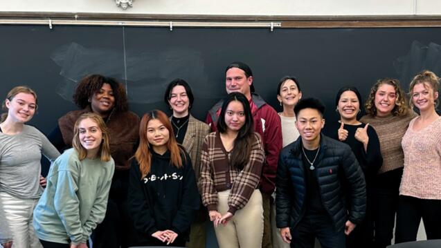 group of college students in front of a chalk board