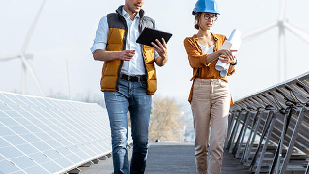 two people walking along a solar farm