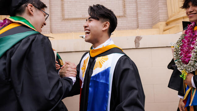 graduating students laughing together at commencement