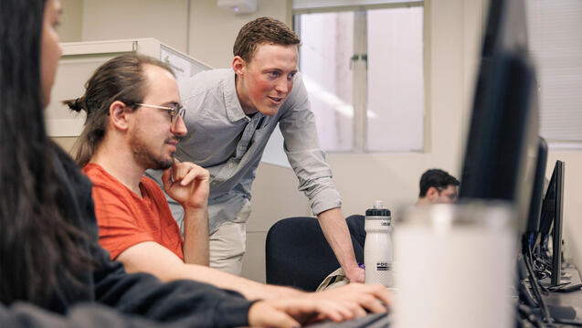 Three students working together on desktop computer