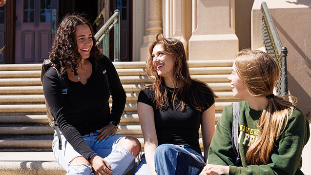 students sit together on steps