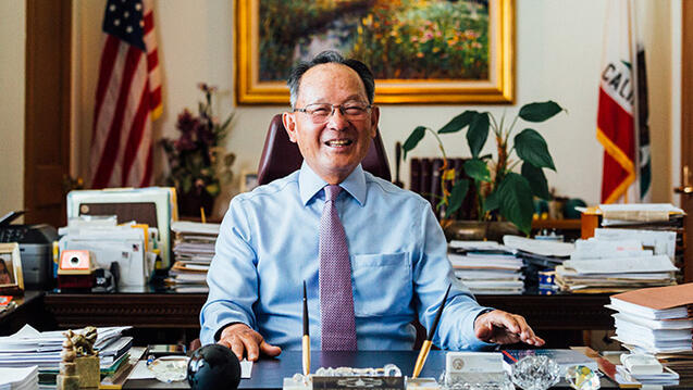 Ming Chin sits at desk