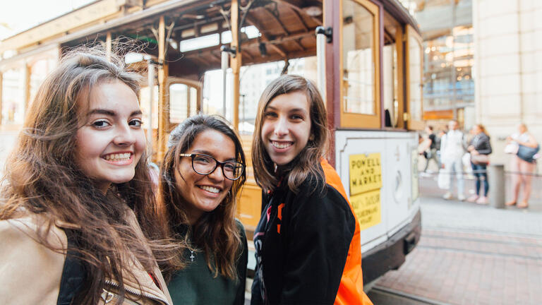 A group of students in front of a cable car.