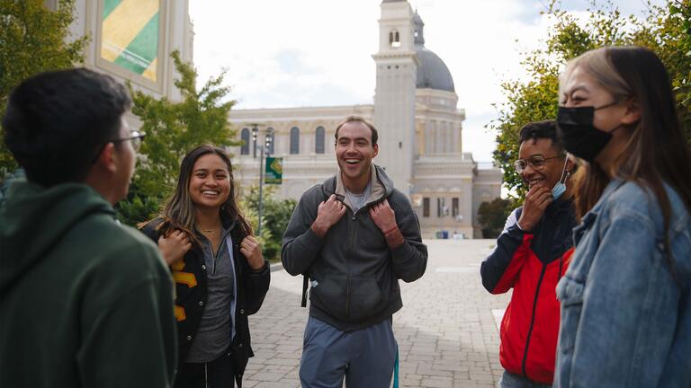 A group of students talk near St. Ignatius Church.