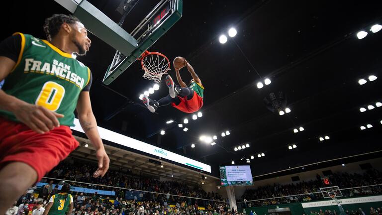 Golden State Warriors Nitro Dunk Team in the air dunking a basketball