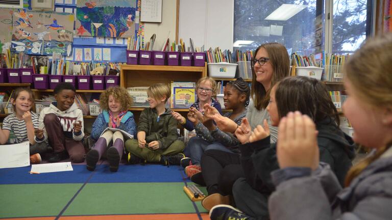 Student sitting in a circle with children