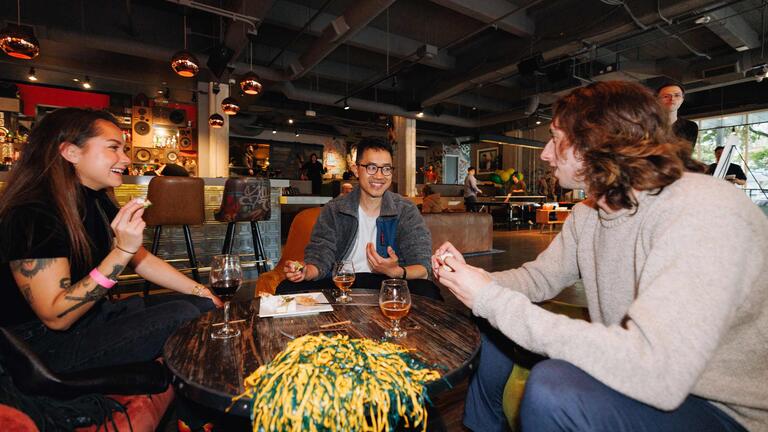 Three USF alumni eating and talking