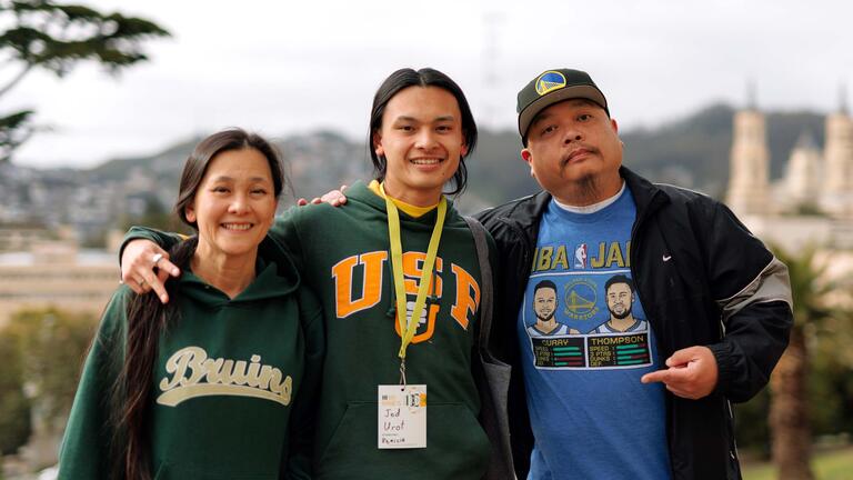 Student standing with parents