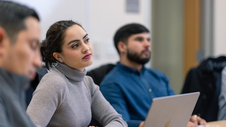 student sitting in classroom in front of laptop