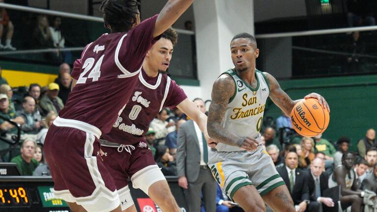 USF men&#039;s basketball player charging past defense.