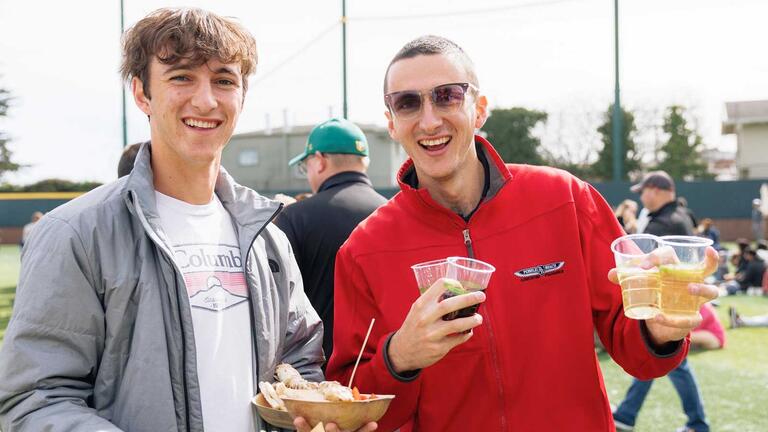 USF alumni holding food and drinks