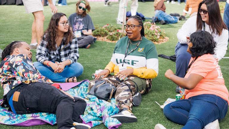 USF alumni sitting on the grass