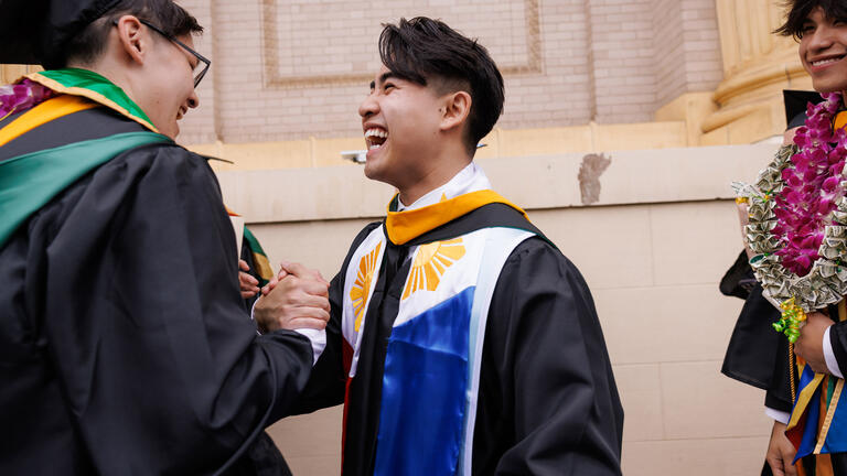 graduating students laughing together at commencement