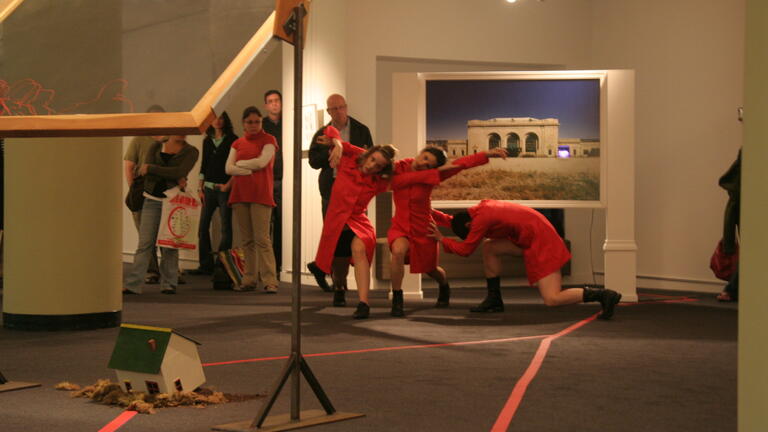 Four performers in red dresses in dynamic poses