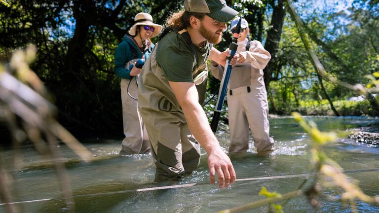 student collecting data in the field for an environment health and hazard study