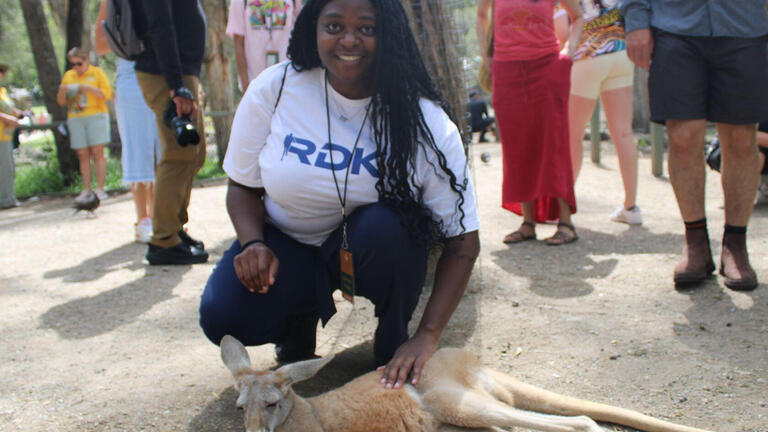 Sport management student petting a kangaroo