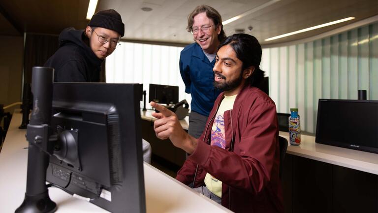 two students and prof. brooks in the computer lab