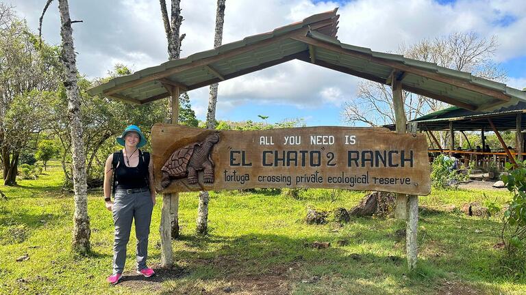 Student standing in front of a sign