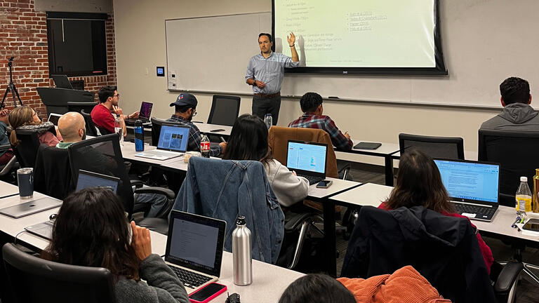 professor sager points at white board in class