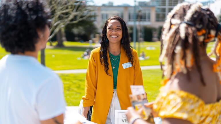 USF representative at a fair table speaking with students