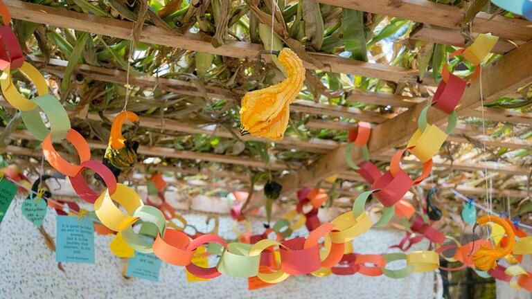 Paper chains and palm fronds adorn a sukkah