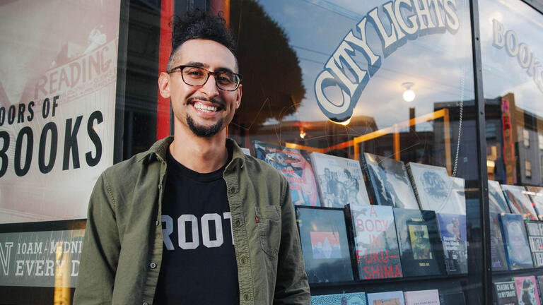 Smiling student in front of bookstore.