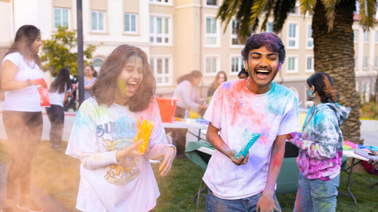 Smiling students in colorful shirts.