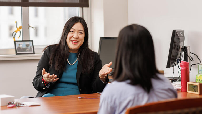 two people talk to one another across table