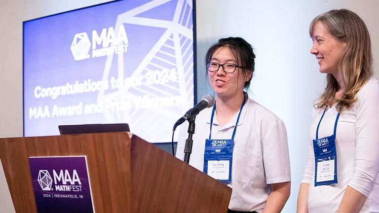 Student and professor standing behind a podium