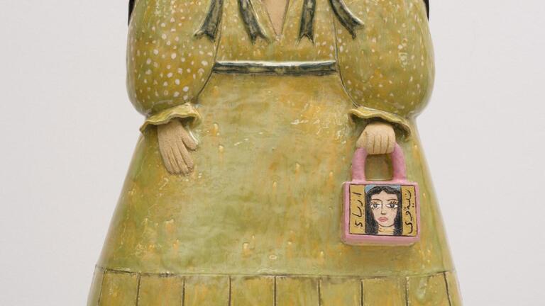 Ceramic figure of woman holding a purse