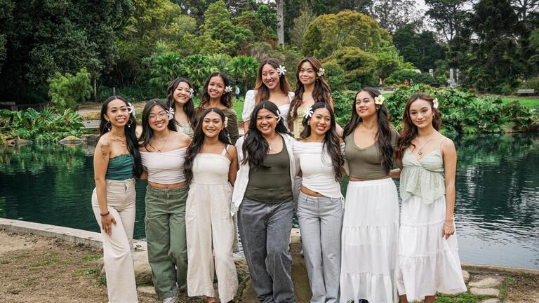 members of the Hawaiian Ensemble posing in front of a pond