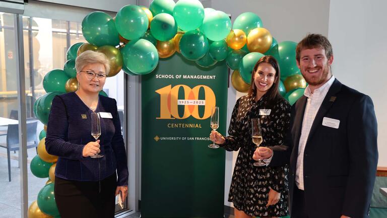 Dean Otgo with two people holding champagne