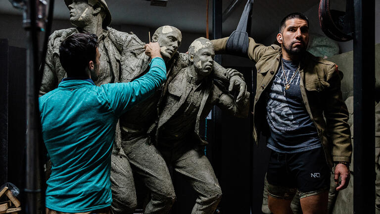 artist works on sculpture