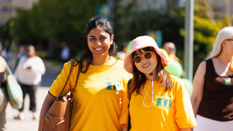 two students wearing som centennial shirts