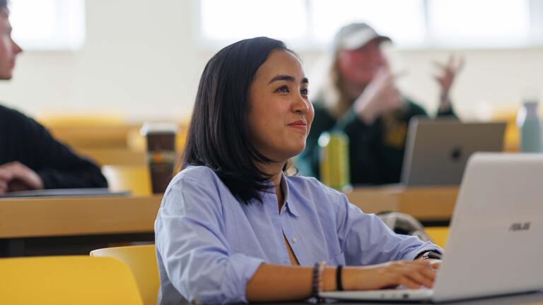 Student with a laptop in lecture