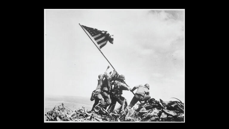 Image of US soldiers lifting flag.