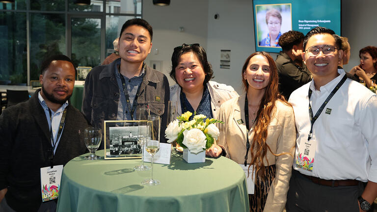 alumni and guest gathered around a table