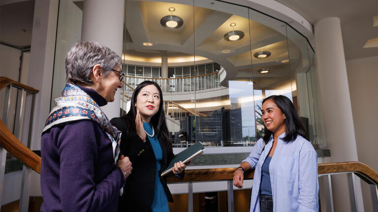 USF student chatting with law professors in USF Law Building