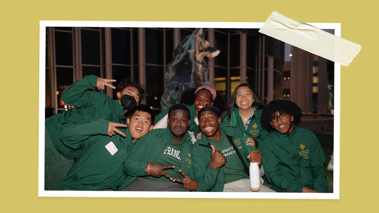 students howling in front of the wolf statues at The Night Howl
