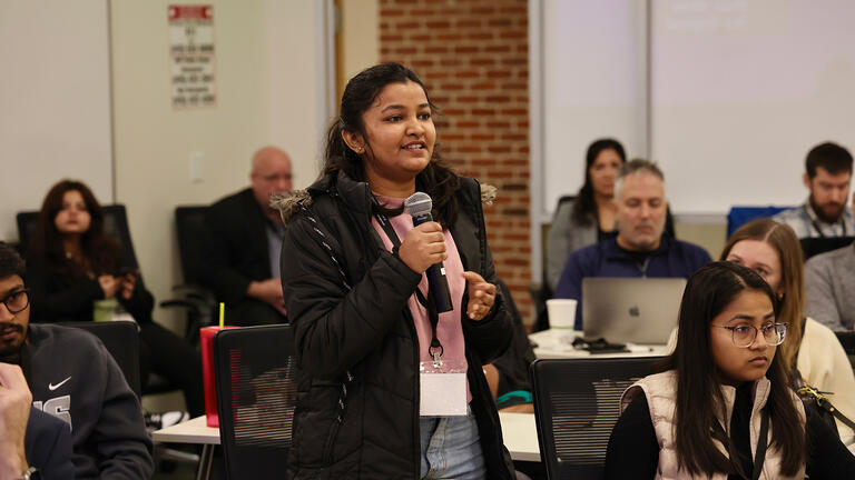 student speaks into microphone during centennial retreat