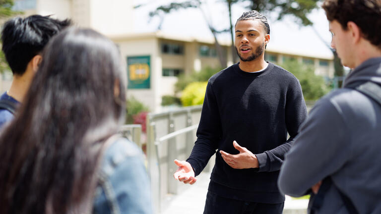 student talks to other students on usf campus